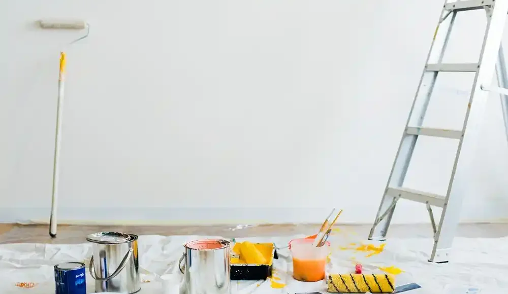 Duvar boyamak için kullanılan rulo, boya kutuları, fırçalar ve merdiven